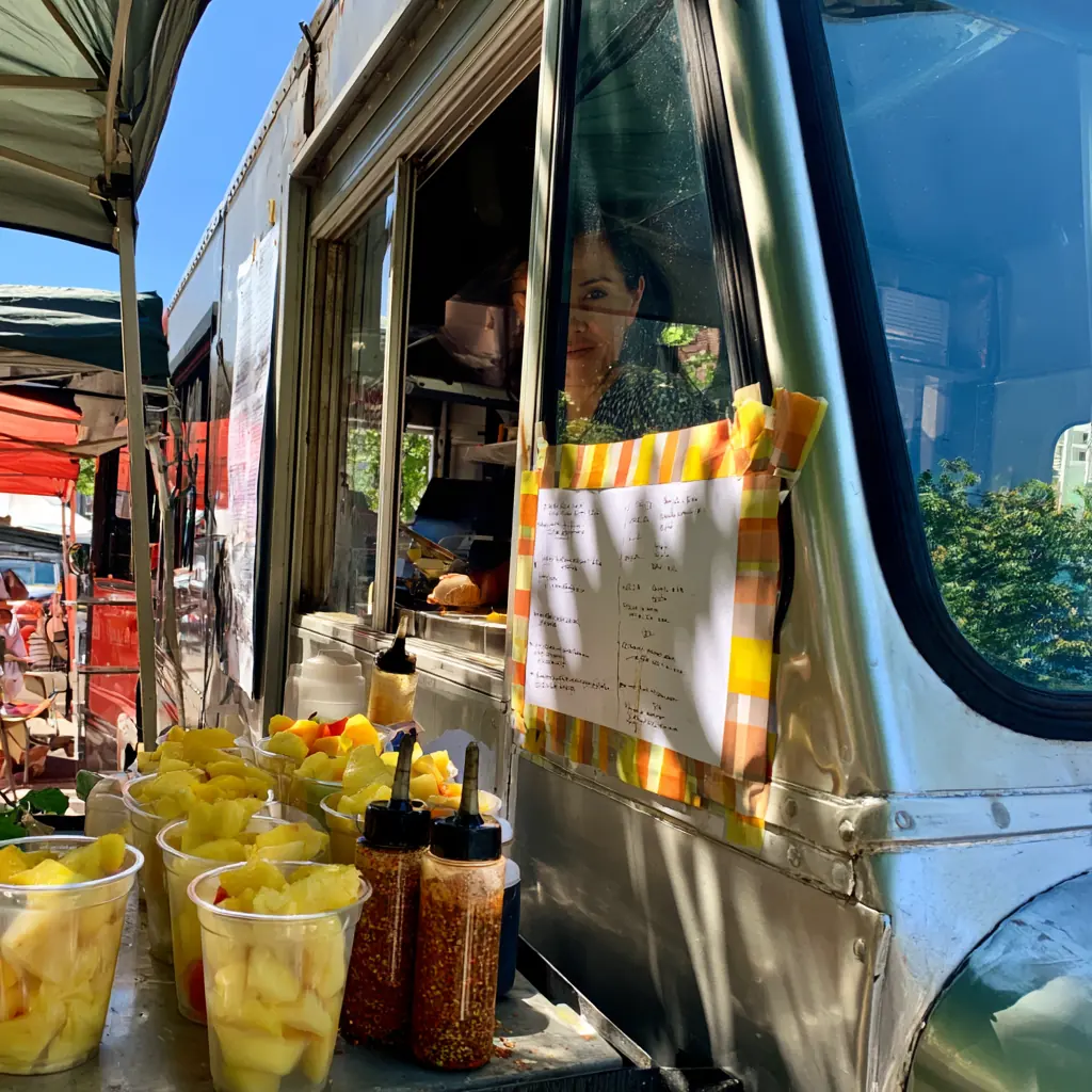 The silver food van with fruit cups and chile shakers lined up on the counter