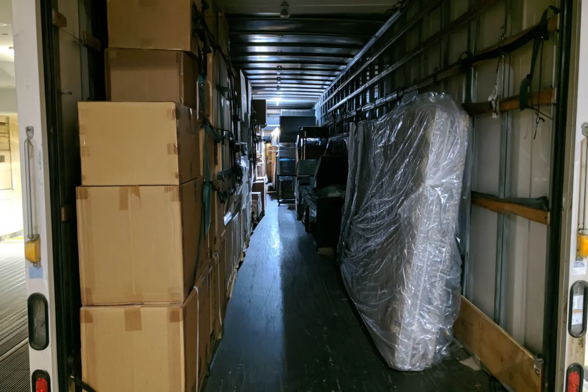 The inside of a moving truck with boxes strapped to the wall